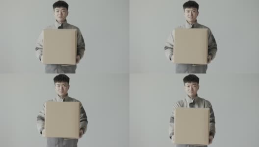 年轻的亚洲快递员穿着快递公司的制服，把快递箱递给了顾客高清在线视频素材下载