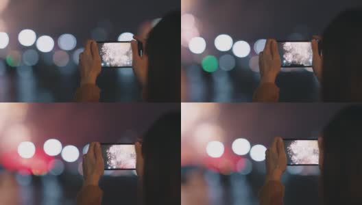 女人用手机拍摄夜空烟花的画面。高清在线视频素材下载