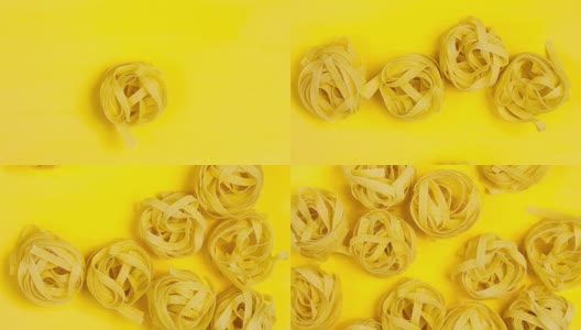 一个生的，干燥的意大利面停止运动。亮黄色背景上的意大利面特写。高清在线视频素材下载