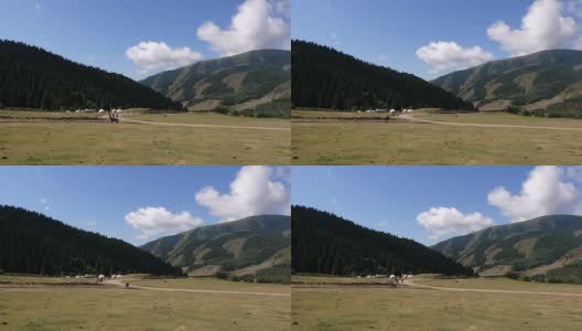 骑马者在田野与天山山脉在吉尔吉斯斯坦高清在线视频素材下载