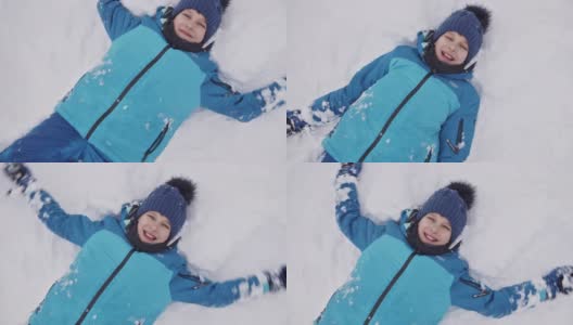 小男孩喜欢在刚下的雪中做一个雪天使高清在线视频素材下载