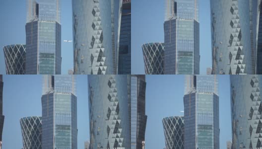 飞机在多哈城市摩天大楼上空飞行的特写视频，卡塔尔。高清在线视频素材下载