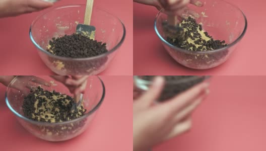 在碗中加入巧克力片和液体巧克力片饼干面团，4K。用慢动作制作饼干面团的概念。高清在线视频素材下载