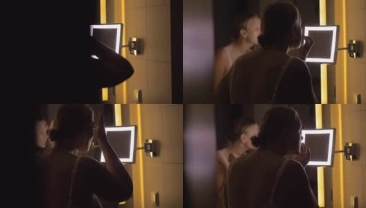 涂抹面霜后对着浴室镜子看的女人高清在线视频素材下载