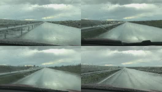 雨滴落在汽车的挡风玻璃上。雨天透过车窗的景色。雨季的概念。高清在线视频素材下载