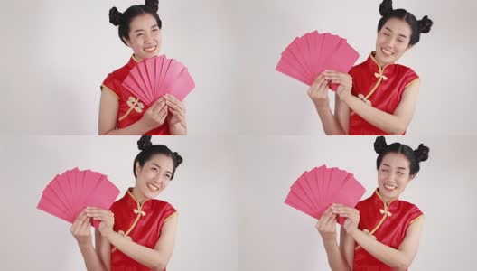 女人穿着旗袍，拿着红包，寓意春节快乐高清在线视频素材下载