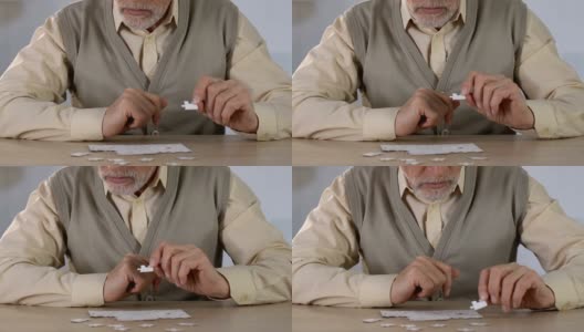 一个老人在康复中心玩拼图游戏，锻炼记忆力高清在线视频素材下载