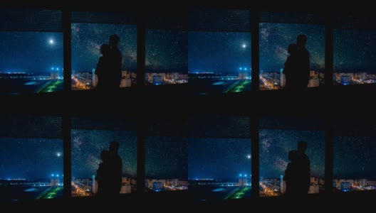 一个男人和一个女人站在可以看到城市夜景的窗边。时间流逝高清在线视频素材下载