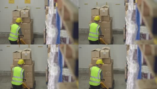 一名男性工人在仓库里拖着叉车高清在线视频素材下载