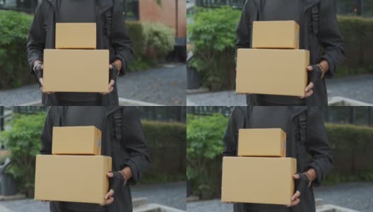 亚洲年轻的快递员拿着包裹盒子高清在线视频素材下载
