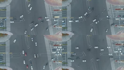 加速无人机拍摄的城市十字路口，汽车和公交车行驶在大道上。在日落时高清在线视频素材下载