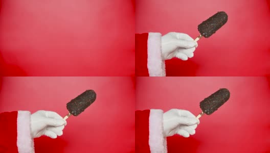 圣诞老人举起一根鲜红的巧克力冰棒高清在线视频素材下载