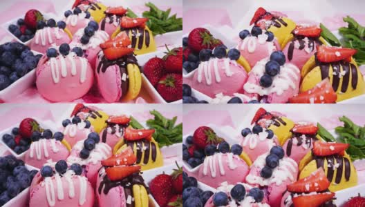 盒装甜品，手工制作的美味食品，马卡龙，巧克力装饰的新鲜草莓和蓝莓甜点，精致的黄色和粉红色蛋糕，糖和健康食品高清在线视频素材下载