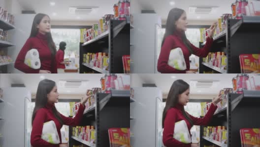 一名亚洲女商人身穿红色便装，正在一家杂货店购买商品和服务高清在线视频素材下载