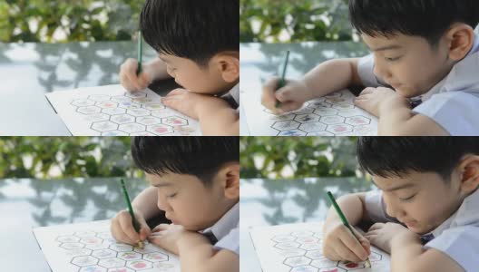 亚洲微笑的孩子学习和做他的家庭作业高清在线视频素材下载