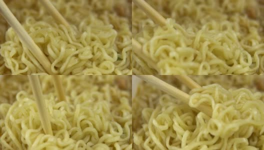 方便面和中国筷子混合在一起。酿造黄色拉面特写高清在线视频素材下载