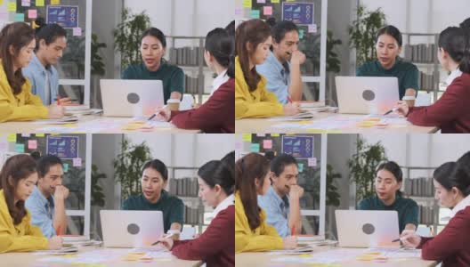 亚洲女性领导者建议ux/ui设计师在现代办公室的桌上进行手机应用界面线框图设计。创意数字发展机构高清在线视频素材下载