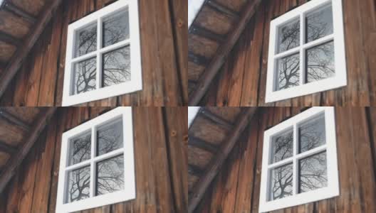 旧谷仓墙上的白色窗户，玻璃上的树的倒影高清在线视频素材下载