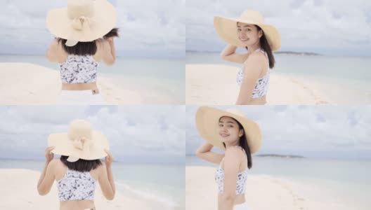 美丽年轻的亚洲女人走在海滩上。高清在线视频素材下载