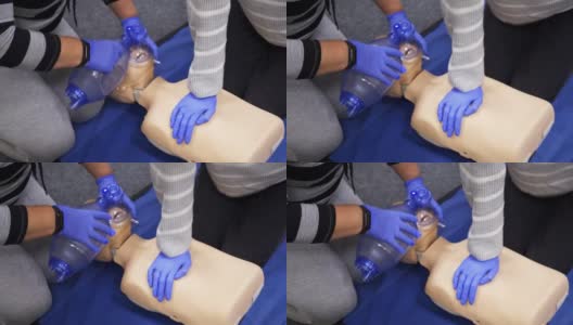 用医用假人训练人们对人体模型进行心肺复苏急救。在一个人体模型上演示胸部压迫。高清在线视频素材下载