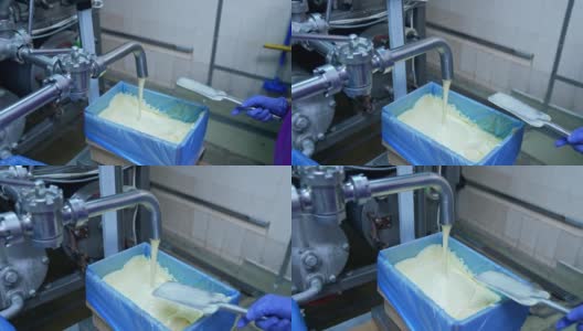 液体黄油正从管子里倒进容器里。生产黄油的工厂。自动化的生产线。粮食生产。高清在线视频素材下载