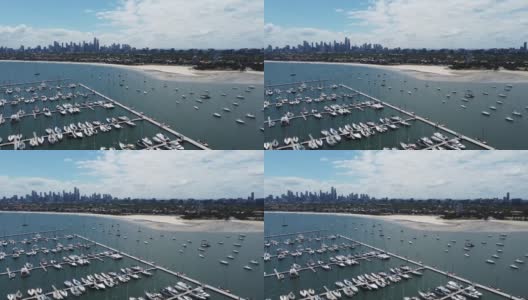 圣基尔达码头位于澳大利亚维多利亚州墨尔本海湾的海滩附近，拥有美丽的CBD或市中心天际线。游艇和帆船停泊在码头上。多云的日子，中午或下午早些时候有太阳。高清在线视频素材下载