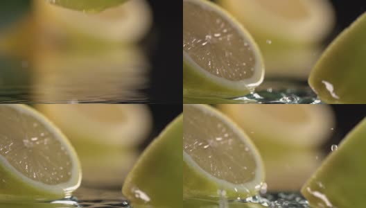 柠檬碰到橙汁表面，然后切成两半。慢动作镜头。近距离高清在线视频素材下载