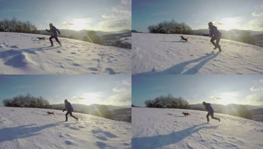 一个女人带着她的狗跑上一座雪山的慢镜头高清在线视频素材下载