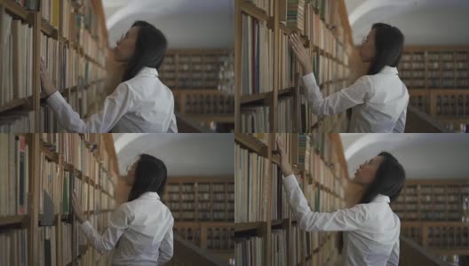 年轻的亚洲女研究员在书架上寻找一本书高清在线视频素材下载