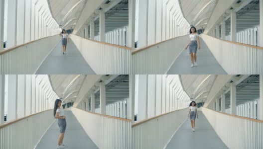快乐年轻的亚洲女人正走在天桥上高清在线视频素材下载
