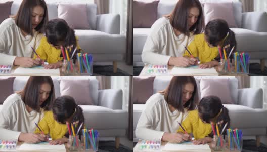 妈妈在家里的客厅教小女孩画画高清在线视频素材下载