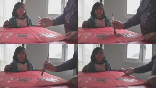 亚洲华裔年轻女孩帮助和学习她的祖父写中国书法高清在线视频素材下载