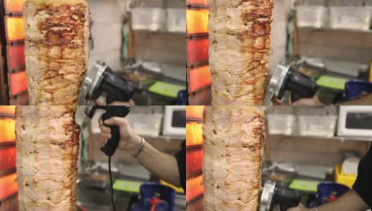 在他的希腊餐厅里，厨师用电动旋转刀从陀螺烤架上切陀螺高清在线视频素材下载