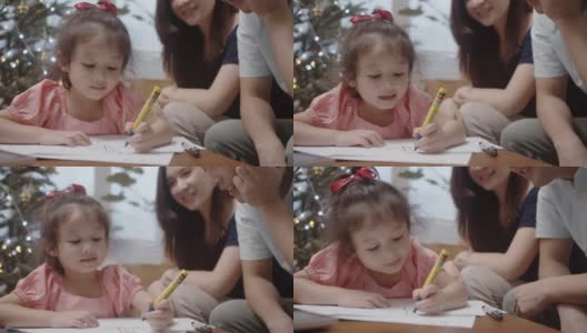 亚洲小女孩和她的父母在家里制作圣诞卡片。高清在线视频素材下载