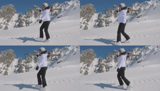 在高山滑雪胜地，一名滑雪者肩上扛着下坡滑雪板前进高清在线视频素材下载