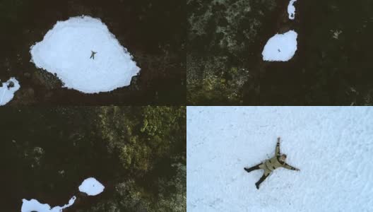 山间的游客躺在白雪覆盖的林间空地上。空中旋转视图高清在线视频素材下载