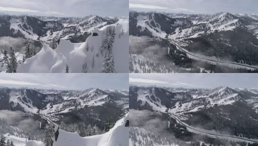 惊人的航拍显示高速公路到冬季滑雪胜地与雪山山峰高清在线视频素材下载