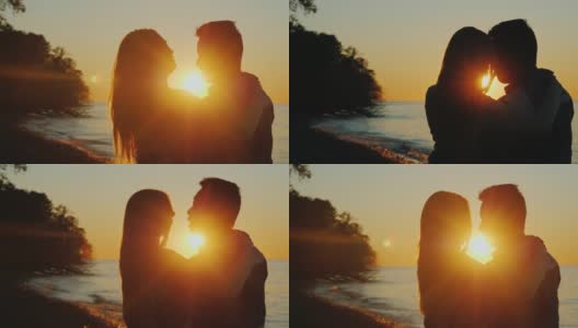 浪漫的多民族情侣在夕阳下拥抱，站在海边。互相看着对方高清在线视频素材下载