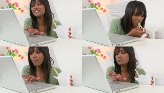 黑人妇女一边用笔记本电脑一边吃中餐外卖高清在线视频素材下载