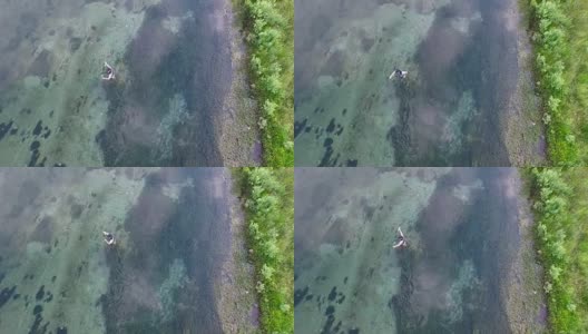 无人机拍摄飞钓者抛钓大鱼的场景。高清在线视频素材下载