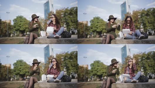 两个不同寻常的女人在街上吃三明治和薯条。高清在线视频素材下载