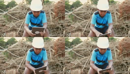 带着工程师帽的亚洲小男孩一个使用数字表，概念我的梦想工程师高清在线视频素材下载