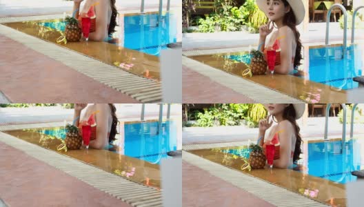 夏天的概念。性感的亚洲女人在橙色比基尼时尚拍摄与热带饮料在游泳池。倾斜了。高清在线视频素材下载