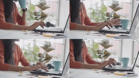 坐在办公室里使用笔记本电脑和喝咖啡的女商人的双手。高清在线视频素材下载
