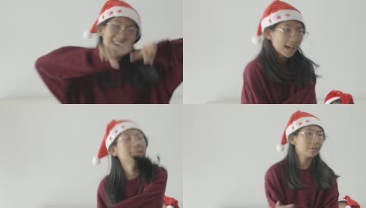 快乐的亚洲儿童戴着圣诞帽和毛衣一起在家里的窗户附近跳舞，圣诞概念。高清在线视频素材下载