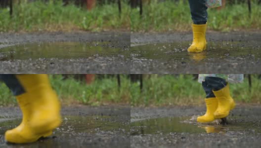 一个穿着黄色胶靴的孩子在雨中的水坑里奔跑玩耍高清在线视频素材下载