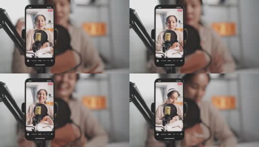 亚洲女性网红使用麦克风戴耳机，用智能手机录制内容，用于在线社交媒体高清在线视频素材下载