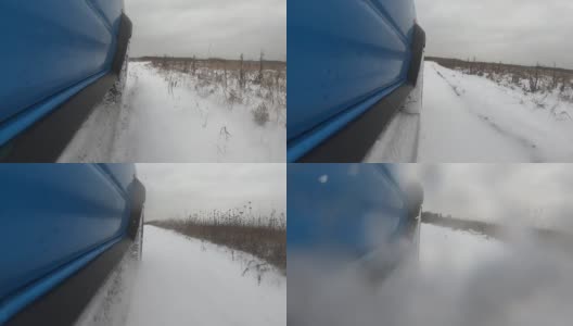 蓝色的汽车在雪地上行驶。雪飞进了相机。侧视图和车轮POV高清在线视频素材下载
