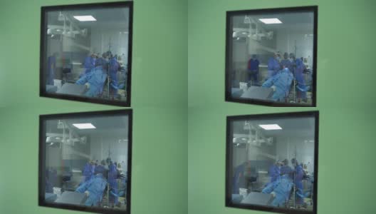 一群穿着防护服的医生在做手术。从走廊进入手术室与医疗专家团队合作。冠状病毒住院治疗。高清在线视频素材下载