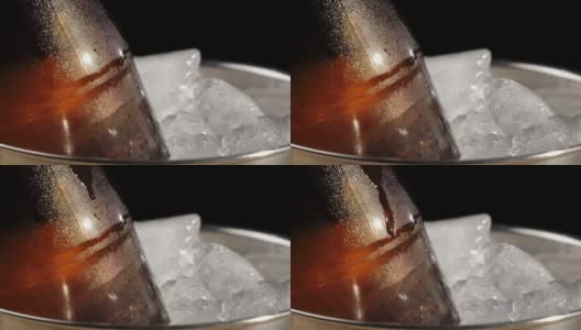 新鲜的啤酒。一滴啤酒从棕色的瓶子里流下来，桶里装着美味的精酿啤酒，黑色的背景衬托着冰冷的真冰。冰镇新鲜啤酒与水滴。准备饮料。关闭了。4 k高清在线视频素材下载
